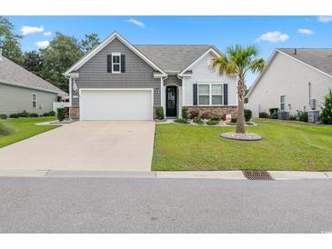 Charming single-story home featuring a well-manicured lawn, palm tree, and a two-car garage at 462 Pacific Commons Dr., Surfside Beach, SC 29575