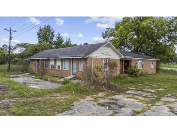 Ranch-style brick home with overgrown landscaping and neglected surroundings at 4860 Highway 378, Conway, SC 29527