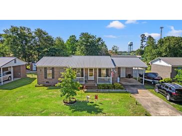 Charming brick home featuring a well-manicured lawn, covered parking, and a welcoming front porch at 517 Cardinal Dr., Conway, SC 29526
