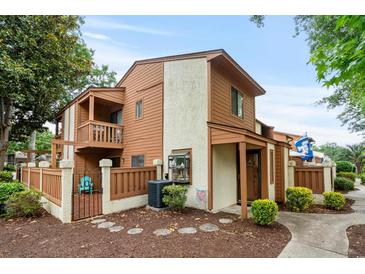 Charming townhouse featuring a private balcony, fenced patio, and well-maintained landscaping at 614 15Th Ave. S # 41, Surfside Beach, SC 29575