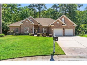 Beautiful brick home featuring a well-manicured lawn and a two-car garage and driveway, offering excellent curb appeal at 6572 Wellington Dr., Murrells Inlet, SC 29576