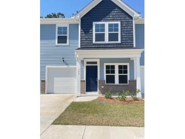 Charming two-story home with blue siding, a garage, and a well-manicured lawn at 786 Nw Palm Frond Way # 51, Calabash, NC 28467