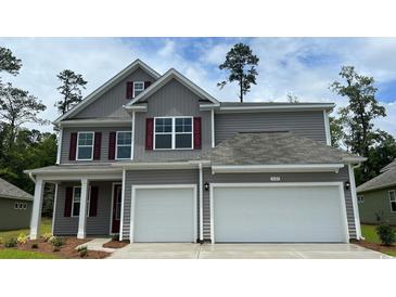 Charming two-story home featuring a gray facade, red shutters, and a spacious two-car garage at 902 Ireland Dr., Longs, SC 29568