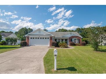 Charming brick home with a well-manicured lawn, mature landscaping, and a spacious two-car garage at 1388 Gailard Dr., Conway, SC 29526