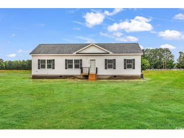 Charming single-story home with a well-maintained lawn and classic design against a bright sky at 1529 Bucksport Rd., Conway, SC 29527