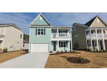 Charming two-story home with a welcoming front porch, a manicured lawn, and an attached garage at 153 Stride Ct., Myrtle Beach, SC 29588