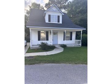Charming home with a cozy front porch, black shutters, and a well-manicured lawn at 1676 Citadel Ln., Myrtle Beach, SC 29577