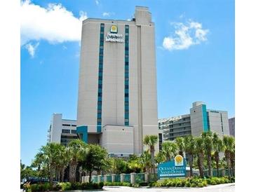 Modern high-rise building features Sand Dunes branding, palm trees, and a bright blue sky at 201 N 74Th Ave. N # 2249/2250, Myrtle Beach, SC 29572