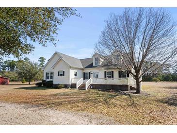 Charming two-story home with a covered front porch, manicured lawn, and mature trees at 589 Loop Circle, Longs, SC 29568