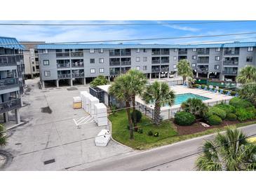 Coastal condominium complex featuring a refreshing swimming pool surrounded by lush landscaping at 6000 N Ocean Blvd. # 329, North Myrtle Beach, SC 29582