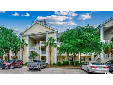 Attractive condo exterior with stacked balconies, mature trees, and ample parking at 601 Hillside Dr. N # 3704, North Myrtle Beach, SC 29582