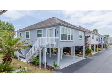 Inviting coastal home featuring a raised structure, stairs, and well-maintained landscaping for charm at 820 9Th Ave. S, North Myrtle Beach, SC 29582
