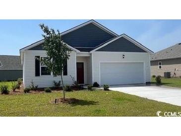 Charming single-story home with a well-manicured lawn and attached two-car garage at 857 Farmers Passage Loop, Loris, SC 29569