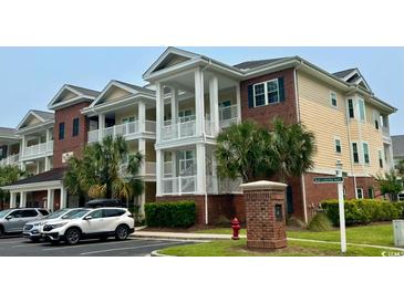 Beautiful condo building with multiple stories and ample parking surrounded by lush landscaping at 1029 Ray Costin Way # Villa 909, Murrells Inlet, SC 29576