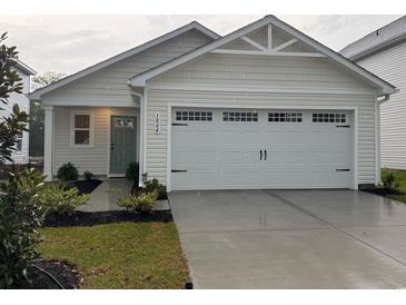 Charming home exterior features a two-car garage, manicured lawn, and traditional architectural details at 1064 Oak Meadow Dr., Conway, SC 29526