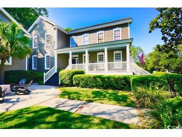 Charming two-story home featuring a covered porch, manicured landscaping, and a well-maintained lawn at 203 Broad St., Georgetown, SC 29440