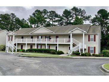 Two story condo building with white railings, stairs, and lush landscaping at 3677 Clay Pond Village Ln. # 6, Myrtle Beach, SC 29579
