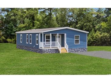 Charming home featuring blue siding, a welcoming front porch, and a well-maintained lawn at 3759 Green Sea Rd., Green Sea, SC 29545