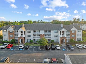 Attractive condo building featuring brick accents, multiple balconies, and ample parking spaces at 3762 Citation Way # 1023, Myrtle Beach, SC 29577