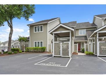 Charming townhouse with dedicated parking and well-maintained landscaping under a bright blue sky at 435 Ocean Creek Dr. # 2722, Myrtle Beach, SC 29572