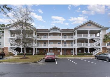 Charming condo building with multiple stories, covered decks, and well-maintained landscaping, near parking at 5750 Oyster Catcher Dr. # 531, North Myrtle Beach, SC 29582