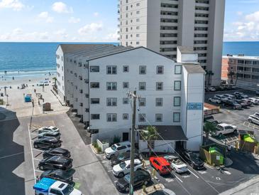Exterior shot of Carolina Shores II, a multi-story condominium building with parking and beach access at 920 N Waccamaw Dr. # 1302, Garden City Beach, SC 29576