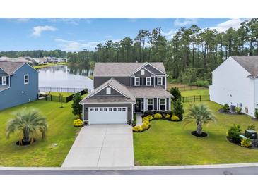 Beautiful two-story home featuring a two-car garage, landscaping, and lake views at 933 Wild Leaf Loop, Conway, SC 29526
