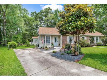Charming single-story home featuring a well-manicured lawn, mature tree, and inviting front entrance at 103 Robin Ct., Murrells Inlet, SC 29576