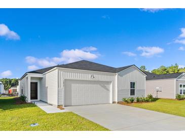 Charming single-story home featuring a two-car garage, and manicured lawn at 144 Warner Crossing Way, Loris, SC 29569
