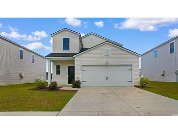 Charming two-story home features a two-car garage, manicured lawn, and classic white siding at 1560 Swing Bridge Way, Myrtle Beach, SC 29588