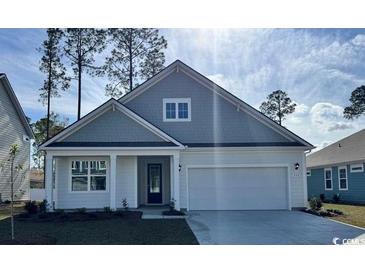 Charming single-story home featuring a two-car garage, well-manicured lawn, and classic architectural details at 161 Stride Ct., Myrtle Beach, SC 29588