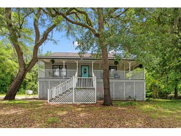 Charming home featuring a spacious front porch and beautiful landscaping in a tranquil setting at 1936 Lees Landing Circle, Conway, SC 29526