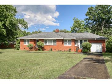 Charming brick home with a well-maintained lawn, mature trees, and an attached one-car garage at 2004 Seitter St., Georgetown, SC 29440