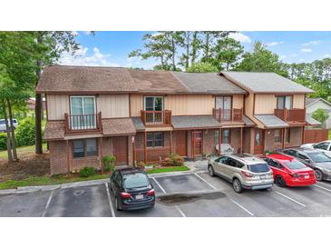 Charming townhome complex featuring brick and siding exteriors, small balconies, and well-maintained parking areas at 218 Waccamaw Village Dr. # 218, Myrtle Beach, SC 29579