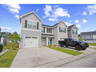 Charming townhome featuring gray siding, black shutters, a white garage door, and a blue front door at 238 Christiana Ln. # C, Myrtle Beach, SC 29579
