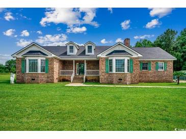 Charming brick home featuring a well-maintained lawn and inviting front porch at 3511 Sumpter Rd., Loris, SC 29569