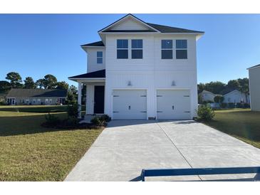 Inviting two-story home boasts a pristine lawn, attached two-car garage, and a charming, modern exterior at 434 Falling Leaf Loop, Myrtle Beach, SC 29588