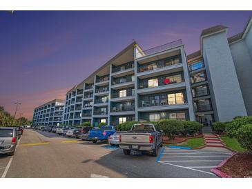 Multi-story condominium complex with parking area and balconies on each level offering outdoor living space at 5905 South Kings Hwy. # 132B, Myrtle Beach, SC 29575
