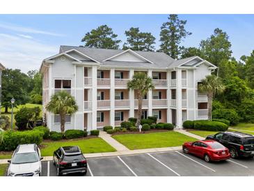 Three-story condo building featuring multiple balconies, green landscaping, and ample parking at 639 Waterway Village Blvd # 14-I, Myrtle Beach, SC 29579
