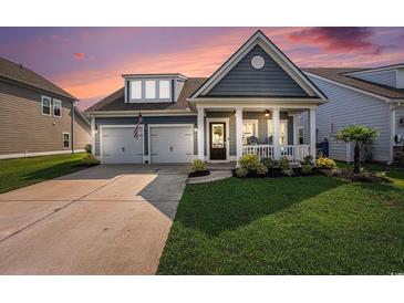 Charming single-Gathering home featuring an inviting front porch, well-manicured lawn, and a two-car garage at 981 Mourning Dove Dr., Myrtle Beach, SC 29577
