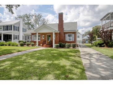 Charming brick home features a lush green lawn and classic architectural details at 104 East Bay St., Georgetown, SC 29440