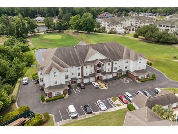 A well-maintained condo building with a parking area and golf course view at 2241 Waterview Dr. # 514, North Myrtle Beach, SC 29582