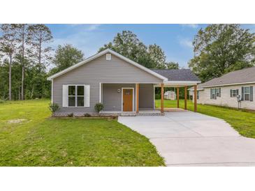 Charming single-story home with gray siding, covered parking, and a well-maintained front yard at 306 S Magnolia Ave., Andrews, SC 29510