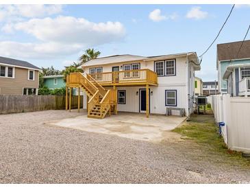 Coastal home featuring a spacious parking area, outdoor stairs, and a second-story balcony at 3202 Inland St., North Myrtle Beach, SC 29582