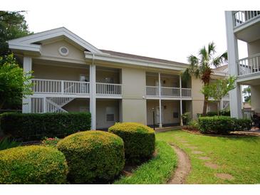 Attractive condo building featuring balconies, lush landscaping, and a serene garden path at 390 Lands End Blvd. # 4-201, Myrtle Beach, SC 29572