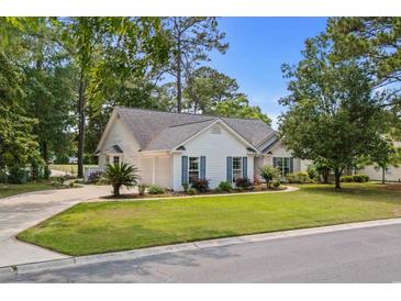 Charming single-story home with white siding, blue shutters, manicured lawn, mature trees, and a paved driveway at 4314 Turtle Ln., Little River, SC 29566