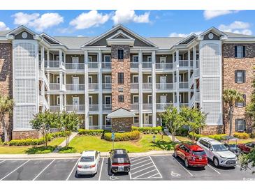 Multi-level condominium building with parking, landscaping, and a well-maintained facade at 4820 Magnolia Lake Dr. # 305, Myrtle Beach, SC 29577