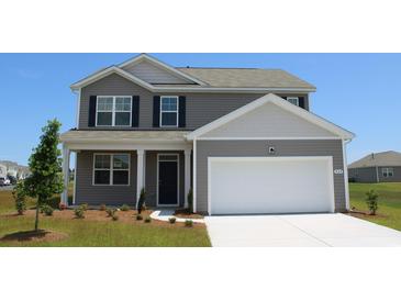 Charming two-story home featuring a neutral color scheme, a two-car garage, and a well-manicured front yard at 5180 Yellowstone Dr., Conway, SC 29526