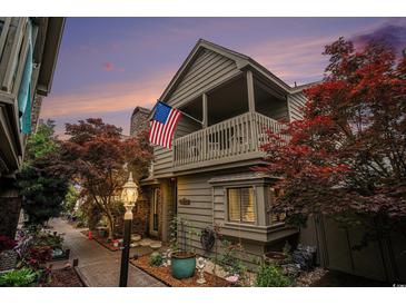 Charming home featuring a covered balcony, beautiful landscaping, and an American flag at 705 11Th Ave. S, North Myrtle Beach, SC 29582
