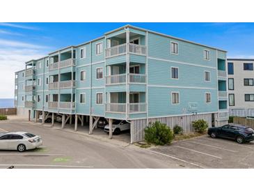 Three story condo building with light blue painted exterior walls, white trim, and multiple balconies for each unit at 824 N Waccamaw Dr. # 203, Murrells Inlet, SC 29576